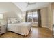 Bright bedroom featuring hardwood floors, a ceiling fan, and large windows with pleasant views at 2449 Xanthia St, Denver, CO 80238