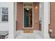 Inviting entryway featuring a green front door, brick facade, and welcoming doormat at 2449 Xanthia St, Denver, CO 80238