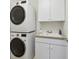 Well-organized laundry room with stacked washer and dryer and built-in cabinets at 2449 Xanthia St, Denver, CO 80238