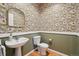 Unique powder room featuring patterned wallpaper, a pedestal sink, and hardwood floors at 2449 Xanthia St, Denver, CO 80238