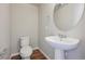 Clean and modern half bathroom with pedestal sink and wood-look tile floor at 457 Interlocken Blvd # 102, Broomfield, CO 80021