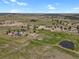 Scenic aerial view of a property nestled among expansive, undulating terrains and a nearby pond at 897 E Rim Rd, Franktown, CO 80116