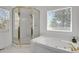 Bathroom featuring a soaking tub, tiled walls, and a separate enclosed glass and gold shower at 897 E Rim Rd, Franktown, CO 80116