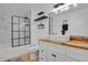 Modern bathroom with wood countertop, designer sink and shower, and stylish black and white tiling at 897 E Rim Rd, Franktown, CO 80116