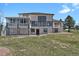 Back of a beautiful house with multiple windows, porches, and a well-maintained lawn at 897 E Rim Rd, Franktown, CO 80116