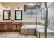 Elegant bathroom featuring dual sinks, a luxurious soaking tub, and a modern glass shower at 23960 E Easter Pl, Aurora, CO 80016