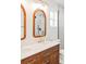 Bathroom vanity features double sinks, wood cabinets, gold faucets, and arched mirrors at 1048 Knox Ct, Denver, CO 80204