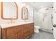 Modern bathroom features wood vanity with double sinks, stylish mirrors, and a glass walk-in shower at 1048 Knox Ct, Denver, CO 80204