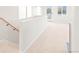 Bright hallway with neutral carpeting, leading to an exterior door and windows at 1048 Knox Ct, Denver, CO 80204