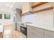 Well-lit kitchen featuring stainless steel appliances, floating shelves, and modern gray cabinetry at 1048 Knox Ct, Denver, CO 80204
