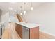 Stylish kitchen island with pendant lighting, wooden cabinets, and stainless steel appliances at 1048 Knox Ct, Denver, CO 80204