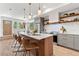 Stylish kitchen featuring wood cabinets, stainless steel appliances, quartz countertop, pendant lights, and barstool seating at 1048 Knox Ct, Denver, CO 80204