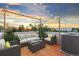 Relaxing rooftop deck featuring comfortable seating and string lights with a sunset view at 1048 Knox Ct, Denver, CO 80204