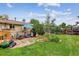 Backyard features a stone patio with Adirondack chairs and a garden area with lush greenery at 11835 W 37Th Pl, Wheat Ridge, CO 80033