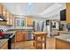 Sunlit kitchen with stainless steel appliances, granite counters, skylights, and wood cabinets at 11835 W 37Th Pl, Wheat Ridge, CO 80033