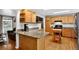 Kitchen with wooden cabinets, modern appliances, granite countertops, and a breakfast bar at 11835 W 37Th Pl, Wheat Ridge, CO 80033