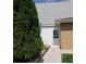 Property back entrance with white walls, a white door, brick walls, and an evergreen tree at 2860 Ames St, Wheat Ridge, CO 80214