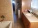 The bathroom has a vanity with a white sink with a view to the laundry area at 2860 Ames St, Wheat Ridge, CO 80214