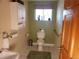 Cozy bathroom featuring tile floors, a toilet, a sink, and a window with natural light at 2860 Ames St, Wheat Ridge, CO 80214