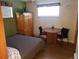 Bright bedroom with a quaint table set, wardrobe, and natural light at 2860 Ames St, Wheat Ridge, CO 80214