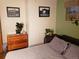 Cozy bedroom features a comfortable bed, wood dresser, and black and white art prints at 2860 Ames St, Wheat Ridge, CO 80214