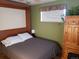 Comfortable bedroom featuring a bed, wooden wardrobe, a nightstand with lamp, and natural light at 2860 Ames St, Wheat Ridge, CO 80214