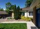 Charming exterior with a brick facade, well-manicured lawn, and attractive landscaping at 2860 Ames St, Wheat Ridge, CO 80214