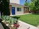A cozy home features a colorful blue door and a well-manicured lawn at 2860 Ames St, Wheat Ridge, CO 80214