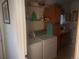 Bright laundry room featuring modern appliances, shelving, and access to an ensuite bathroom at 2860 Ames St, Wheat Ridge, CO 80214
