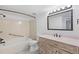 Bathroom with a large mirror, wood vanity, and shower-tub combo at 10890 W Evans Ave # 1G, Lakewood, CO 80227
