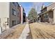Exterior shot of the townhomes with a walkway, grass, and bare trees at 10890 W Evans Ave # 1G, Lakewood, CO 80227