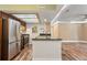 Well-lit open kitchen with stainless steel appliances, breakfast bar, and wood floors at 10890 W Evans Ave # 1G, Lakewood, CO 80227
