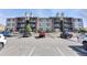 View of a parking lot with assigned visitor spots and multiple parked cars at 10890 W Evans Ave # 1G, Lakewood, CO 80227