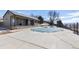 Community pool covered in the off season with snow and ice; buildings and trees surround the pool at 10890 W Evans Ave # 1G, Lakewood, CO 80227