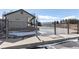 Community pool secured with a metal fence and gate; views of neighborhood and mountains in the background at 10890 W Evans Ave # 1G, Lakewood, CO 80227