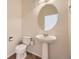 Clean powder room with pedestal sink and round mirror at 8379 Hackamore Rd, Littleton, CO 80125