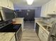 Galley kitchen features stainless appliances and stone-look countertops opening up to a dining area at 8600 E Alameda Ave # 105, Denver, CO 80247