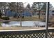 View of a partially frozen pond surrounded by mature trees and blue apartment buildings at 8600 E Alameda Ave # 105, Denver, CO 80247