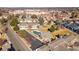 An aerial view of a community pool with a parking lot, clubhouse, townhomes, and commercial development nearby at 7176 S Vine E Cir, Centennial, CO 80122