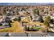 An aerial view shows residences, green space, trees, putting green, and pool in a community with mountain views at 7176 S Vine E Cir, Centennial, CO 80122