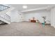 Finished basement shows neutral carpet, white walls, under stair access, and utility closet at 7176 S Vine E Cir, Centennial, CO 80122