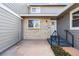 A covered front porch features a small set of stairs, an outdoor light, and a white-trimmed front door at 7176 S Vine E Cir, Centennial, CO 80122