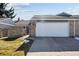 Exterior view of the home's two-car garage with an American flag in the brick facade at 7176 S Vine E Cir, Centennial, CO 80122