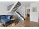 Living room showcases stairs with black railing and hardwood floors next to blue couch at 7176 S Vine E Cir, Centennial, CO 80122