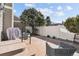 Enclosed back patio features concrete flooring, gray wicker chairs, and privacy fence at 7176 S Vine E Cir, Centennial, CO 80122