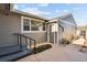 Side entrance featuring stairs, gray siding, and an exterior door, complemented by green bushes at 7176 S Vine E Cir, Centennial, CO 80122