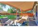 Relaxing covered patio with comfortable seating overlooks the beautifully landscaped backyard and garden at 2337 S Franklin St, Denver, CO 80210