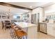 Modern open kitchen featuring stainless steel appliances, white cabinetry, an island with seating, and a spacious dining area at 2337 S Franklin St, Denver, CO 80210