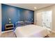 Serene bedroom with a deep blue accent wall, modern lighting, and a doorway to the luxurious en-suite bathroom at 2337 S Franklin St, Denver, CO 80210
