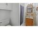 This bathroom includes a toilet, sink, vanity, mirror, medicine cabinet, and shower with a curtain at 892 S Union Blvd, Lakewood, CO 80228